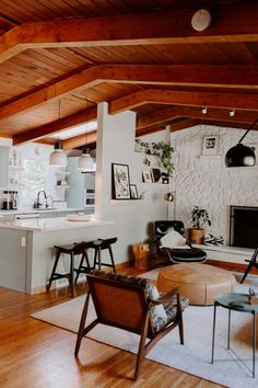 a living room filled with furniture and a fire place in the middle of a kitchen