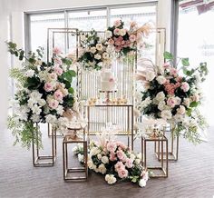 an arrangement of flowers and birdcages on display in a room