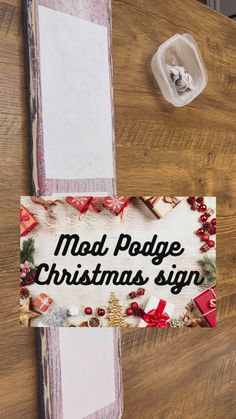 a sign that says mad podge christmas sign on the side of a wooden table