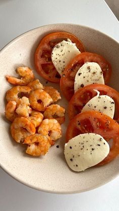 a white plate topped with tomatoes and shrimp