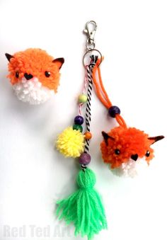 two pom poms with tassels attached to them