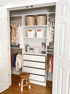 an open closet with clothes and baskets on the shelves, next to a step stool
