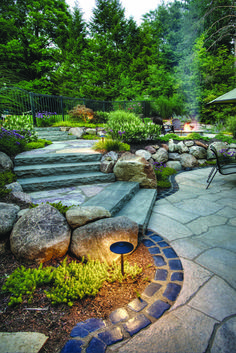 an outdoor patio with stone steps and landscaping