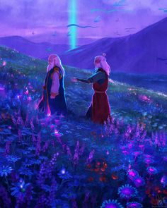 two people standing in a field with purple flowers and mountains behind them, looking at the sky