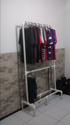 there is a rack with clothes on it in the room next to a tiled wall