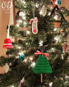 a crocheted christmas tree ornament hanging from the top of a pine tree