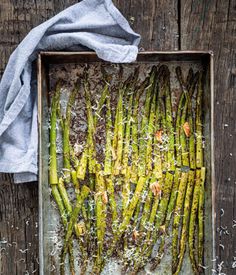 roasted asparagus in a baking pan with parmesan cheese on the side