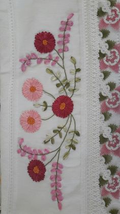 embroidered flowers and vines on white linen with pink trimmings are featured in this image