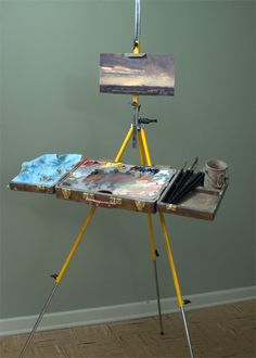 an artist's easel with paint and brushes on it