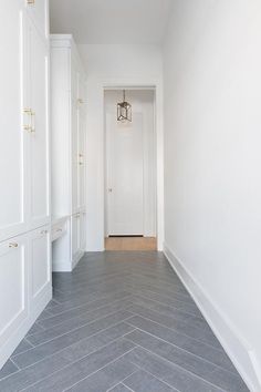 Gray slate herringbone pattern floor tiles accent white shaker mudroom cabinets stacked and fitted with brass and glass pulls. Herringbone Tile Floors, Tile Floor, Herringbone Brick Pattern, Grey Floor Tiles, Herringbone Floor, Herringbone Tile, Brick Flooring, Grey Flooring