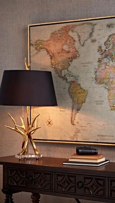 a table with a lamp and a map on the wall