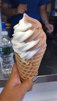 a hand holding up an ice cream cone