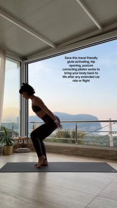 a woman is doing yoga in front of a large window with an inspirational quote on it