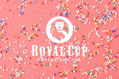the logo for royal cup coffee and tea surrounded by sprinkles on a pink background