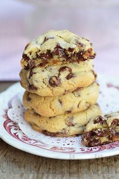 three chocolate chip cookies stacked on top of each other in a white and red plate