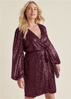 Give a toast to this head-turning mini dress. Shimmering with all-over sequins, balloon-sleeves and a flouncy tulip-hem skirt add even more pizazz. Adjust the wrap silhouette to your desired fit with the sequin sash belt. Add glittering earrings plus heels, then you're set to celebrate.  * Sizes: XS (2), S (4-6), M (8-10), L (12-14), XL (16)  * Plus sizes: 1X (18-20), 2X (22-24), 3X (26-28)  * True wrap silhouette with belt tie closure  * 34.5" approx length  * Elastic at waist and sleeve cuffs Dresses, Toast, Sequin Wrap Dress, Sequin Sash, Purple Dress, Dress Jewelry, Wrap Dress, Wrap Dress Short, Sequin Fabric
