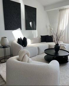 a living room with white furniture and black accents