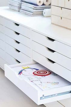 an open drawer in a white dresser with drawers