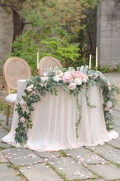 a table with flowers and candles on it is set up for an outdoor wedding reception