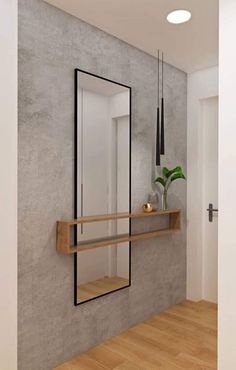 an empty room with a mirror, shelf and plant on the wall next to it