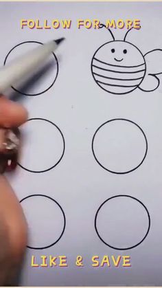 someone is writing on a piece of paper that has circles and a bee drawn on it