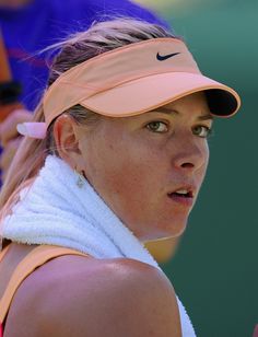 a female tennis player wearing a pink visor