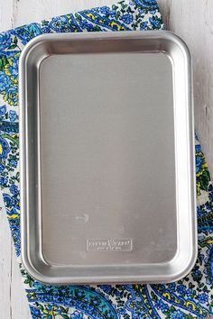 a metal pan sitting on top of a blue and yellow napkin
