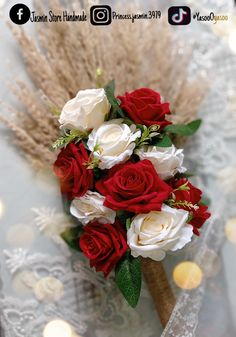 a bridal bouquet with red and white roses on a lace tablecloth, surrounded by wheat stalks