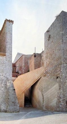 an old brick building with a ramp going through it
