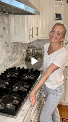 a woman standing in front of an oven smiling