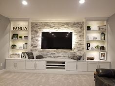 a living room with built - in entertainment center, couch and tv on the wall