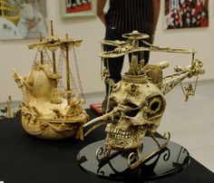 there are two sculptures on display in the room, one skull and one pirate ship