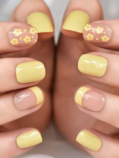 a woman's hands with yellow and pink nail polishes on their nails,