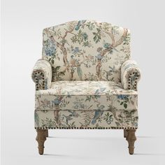 an upholstered chair with birds and flowers on the back, sitting in front of a white background