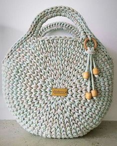 a woven bag with wooden handles and tassels