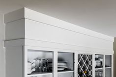 a kitchen with white cabinets and dishes in it