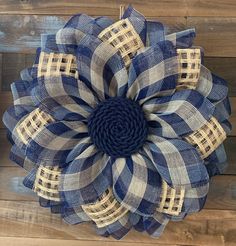 a blue and white plaid flower on a wooden wall