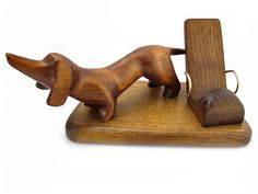 a wooden toy dog on a stand with a piece of wood in it's mouth