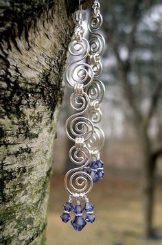 a pair of earrings hanging from the side of a tree