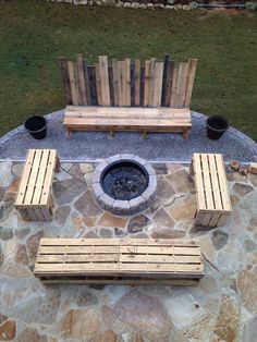 an outdoor fire pit with benches around it
