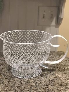 a white wire basket sitting on top of a counter