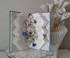 an open book with paper flowers on it
