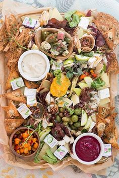 a platter filled with lots of different types of appetizers and dips