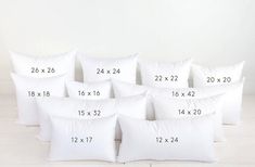 six white pillows with numbers on them are sitting in front of a white wall and floor