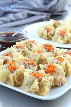 two white plates filled with dumplings covered in meat and carrots