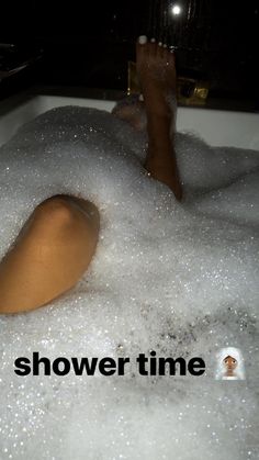 a person laying down in a bathtub with bubbles
