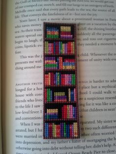 a bookmark made out of colored beads sitting on top of an open book page