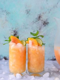 two glasses filled with orange juice and garnished with lime