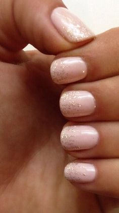 a woman's hand with pink and gold nail polish on her nails, showing the tip