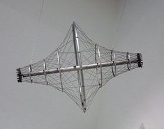 a large metal structure suspended from the ceiling with wires attached to it's sides